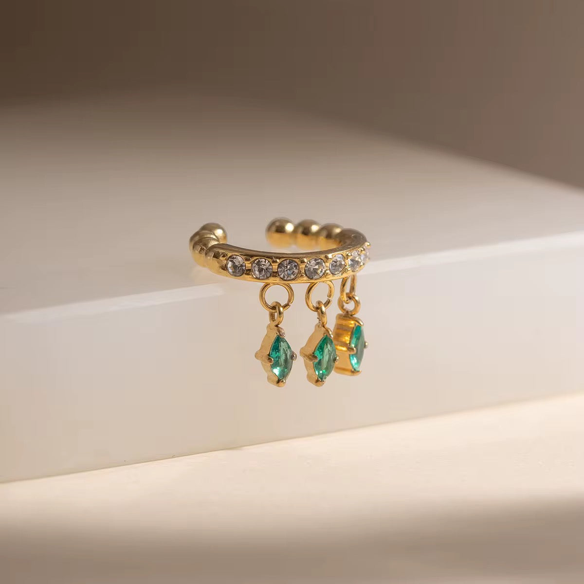 Detail of the brilliant Clear CZ diamond-shaped charms on an 18k gold ear cuff.