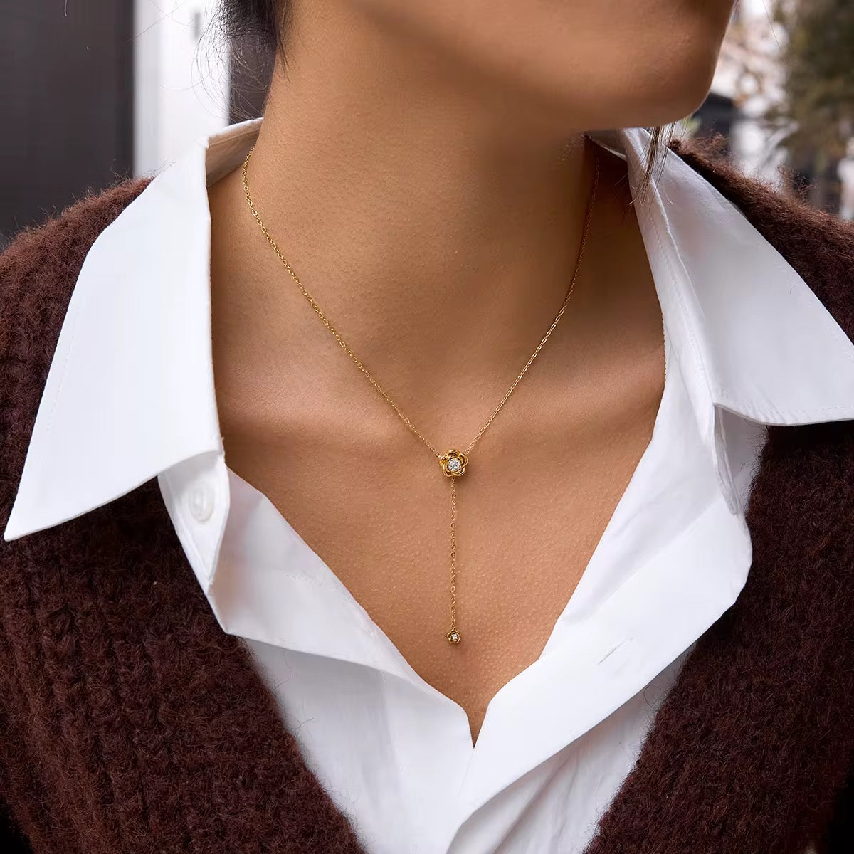 Rose Cascade lariat necklace featuring 18k gold PVD plating and detailed rose pendants.