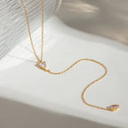 Gilded Tear lariat necklace featuring 18k gold PVD plating and dual teardrop crystals.