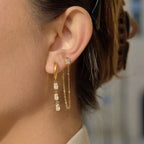 Waterproof gold curated earring stack with teardrop crystals for swimming and active wear.