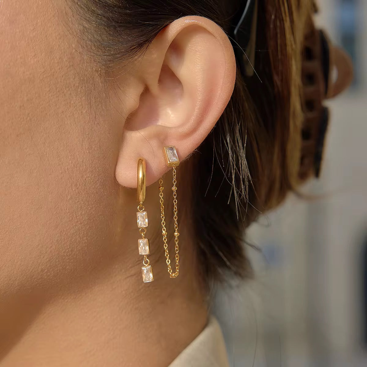 Waterproof gold curated earring stack with teardrop crystals for swimming and active wear.