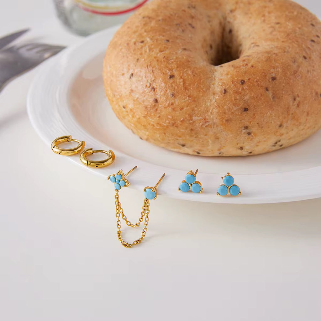 Waterproof gold earring stack with turquoise studs and connector chain for swimming.