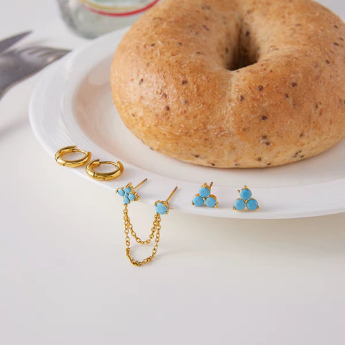 Waterproof gold earring stack with turquoise studs and connector chain for swimming.