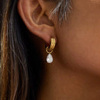 Gilded Teardrop huggie earrings with 18k gold PVD plating and oversized pear-cut crystals.
