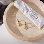 Waterproof gold evil eye hoop earrings for swimming and active lifestyles.