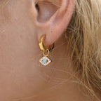Detail of the brilliant-cut crystals and turquoise center on diamond-shaped evil eye drops.