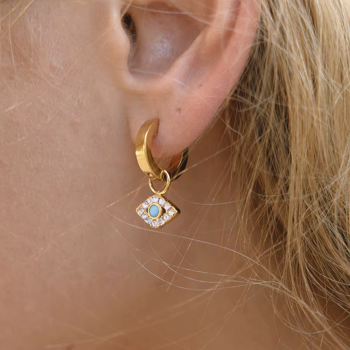 Detail of the brilliant-cut crystals and turquoise center on diamond-shaped evil eye drops.