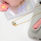 Waterproof gold evil eye necklace with a crystal halo and blue gemstone center.