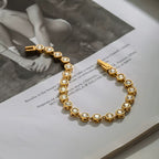 Gilded Solitaire tennis bracelet featuring 18k gold PVD plated stainless steel and crystals.