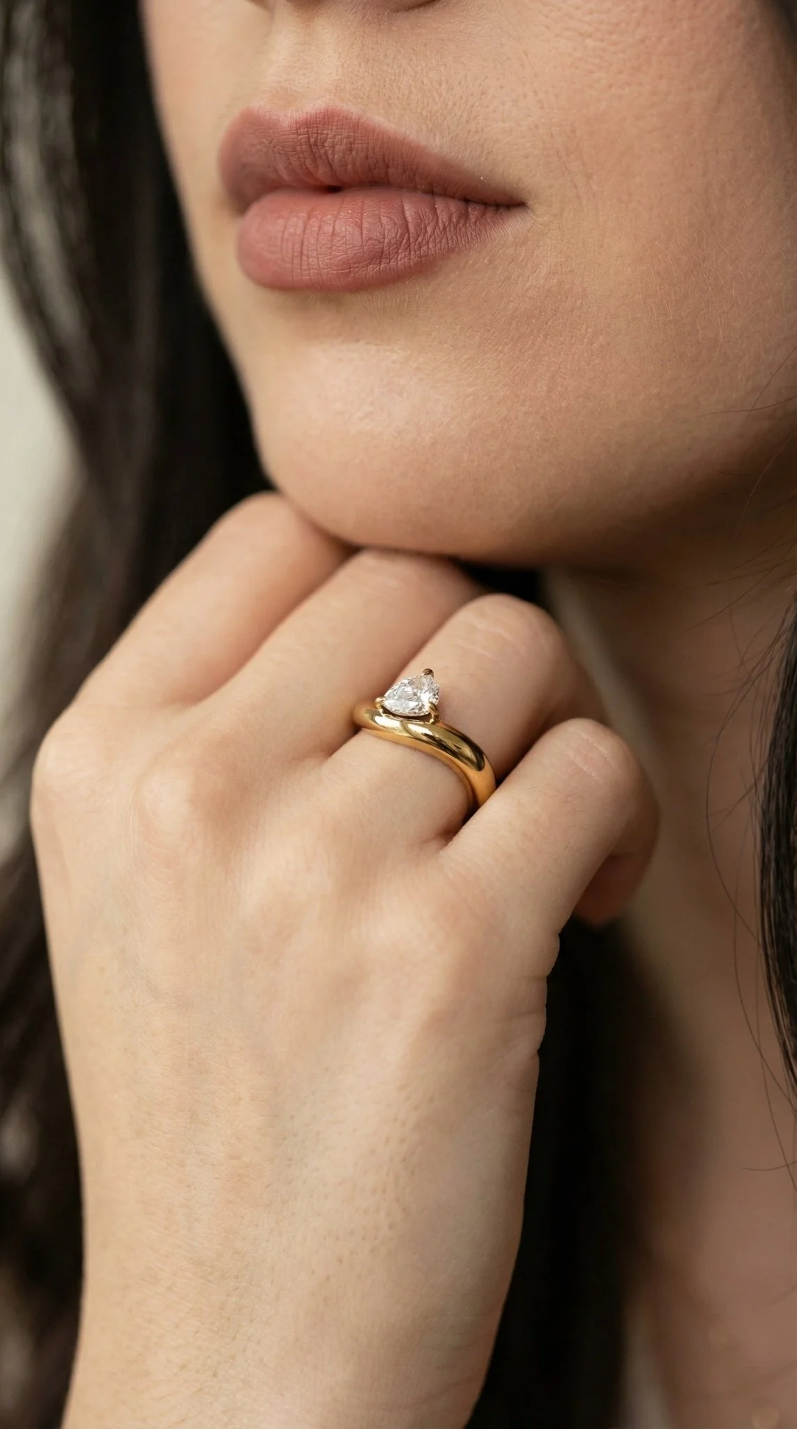 Waterproof gold asymmetrical statement ring with a brilliant-cut teardrop solitaire.