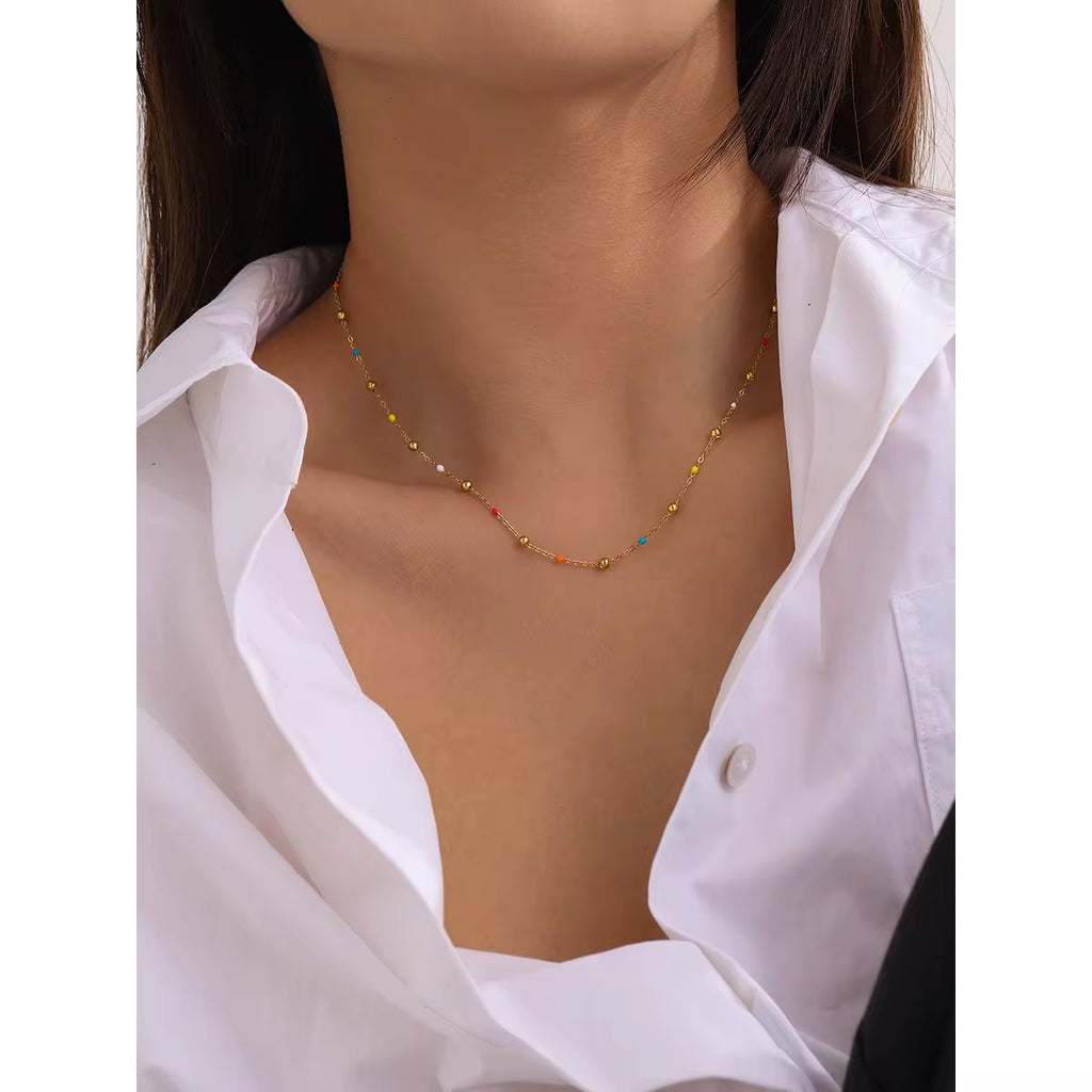 Detail of the delicate gold spheres and vibrant multi-colored station beads on a fine chain.