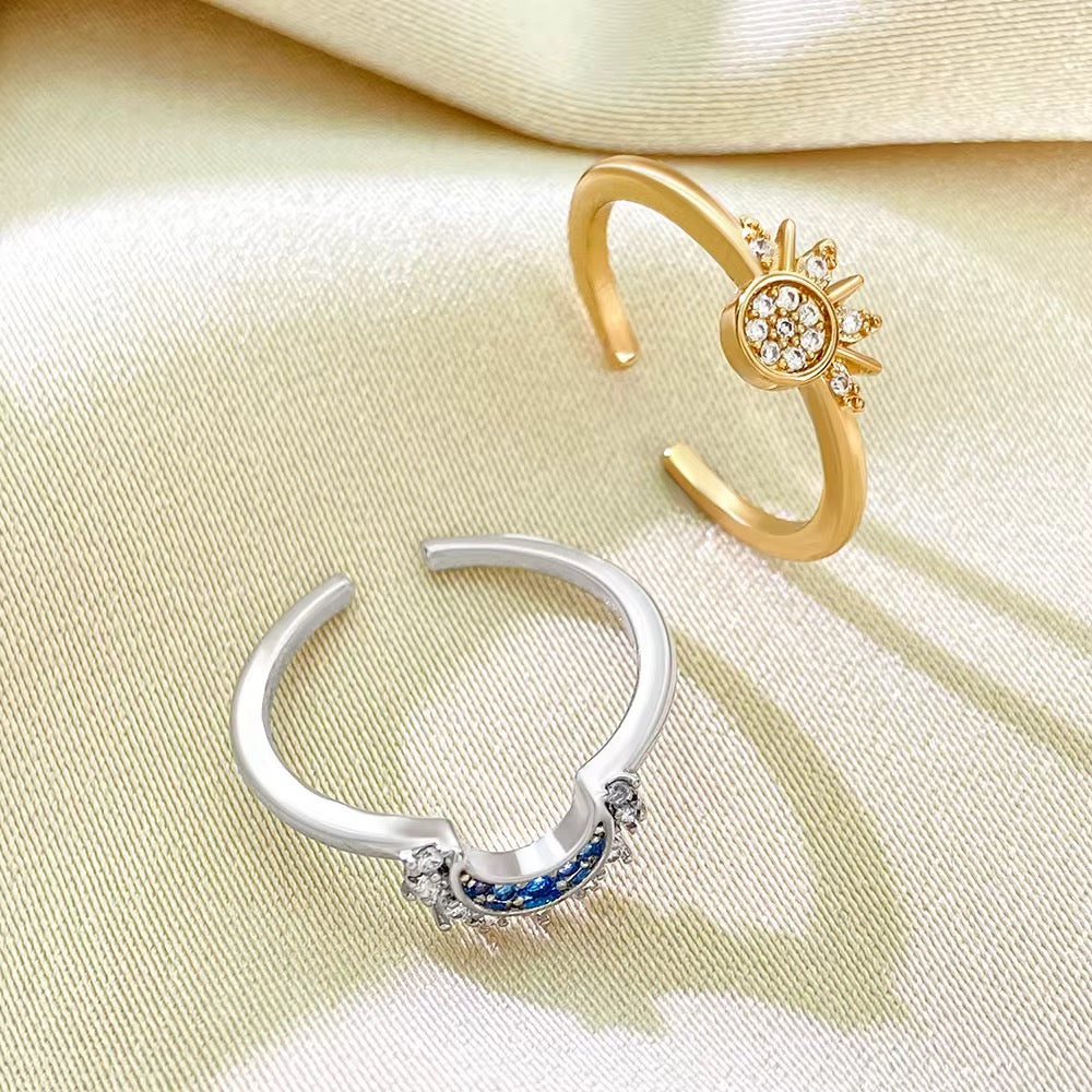 Sol and Luna celestial sun and moon adjustable open rings resting on champagne silk fabric.