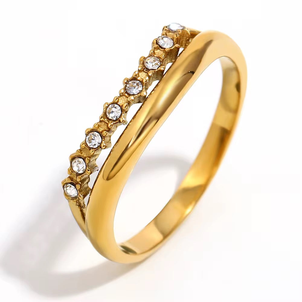Waterproof gold ring featuring a dual band style with a row of seven dark green emerald crystals.