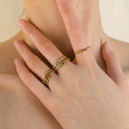 Anya rainbow bezel eternity ring in 18k gold PVD plated stainless steel on a white background.