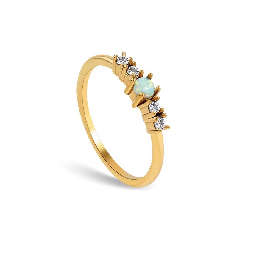 Eternal opal starburst band ring in 18k gold PVD plated stainless steel on white backdrop.