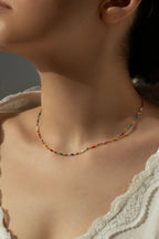 Waterproof gold choker necklace featuring colorful rainbow enamel beads arranged on a dainty lip chain.