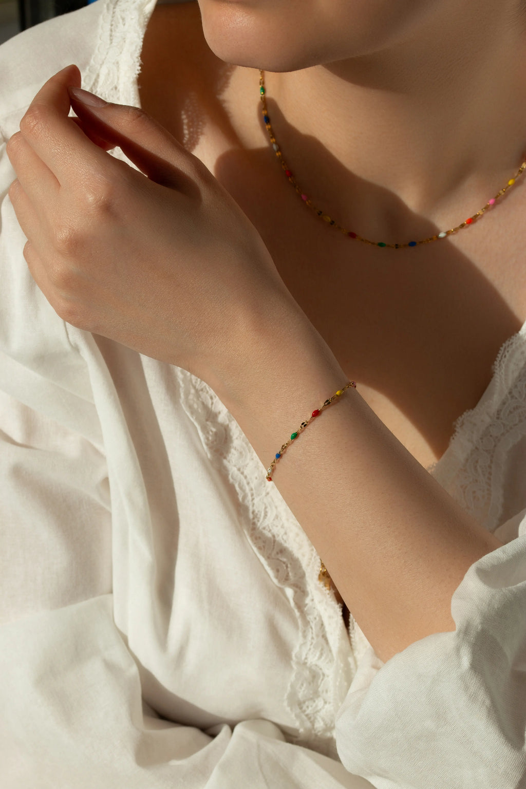 Waterproof gold chain bracelet featuring vibrant rainbow enamel beads arranged on a dainty lip chain.
