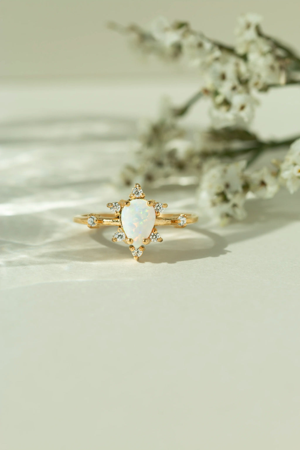 Unique natural teardrop opal engagement ring with a vintage inspired diamond cluster band. Alternative bridal jewelry and boho gemstone promise ring for women.