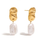 Gold earrings with white pearl drops on a white background