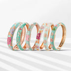 Set of floral-patterned bangles with gold accents on a white background