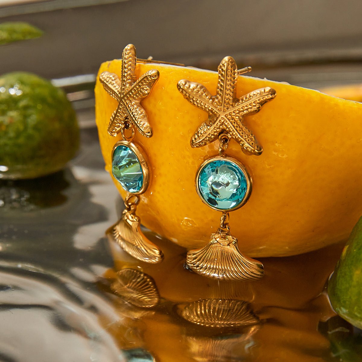 Gold earrings with starfish and turquoise stones on a yellow background