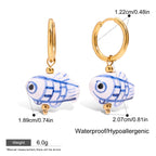 Gold hoop earrings with fish charms, showing measurements and product details.