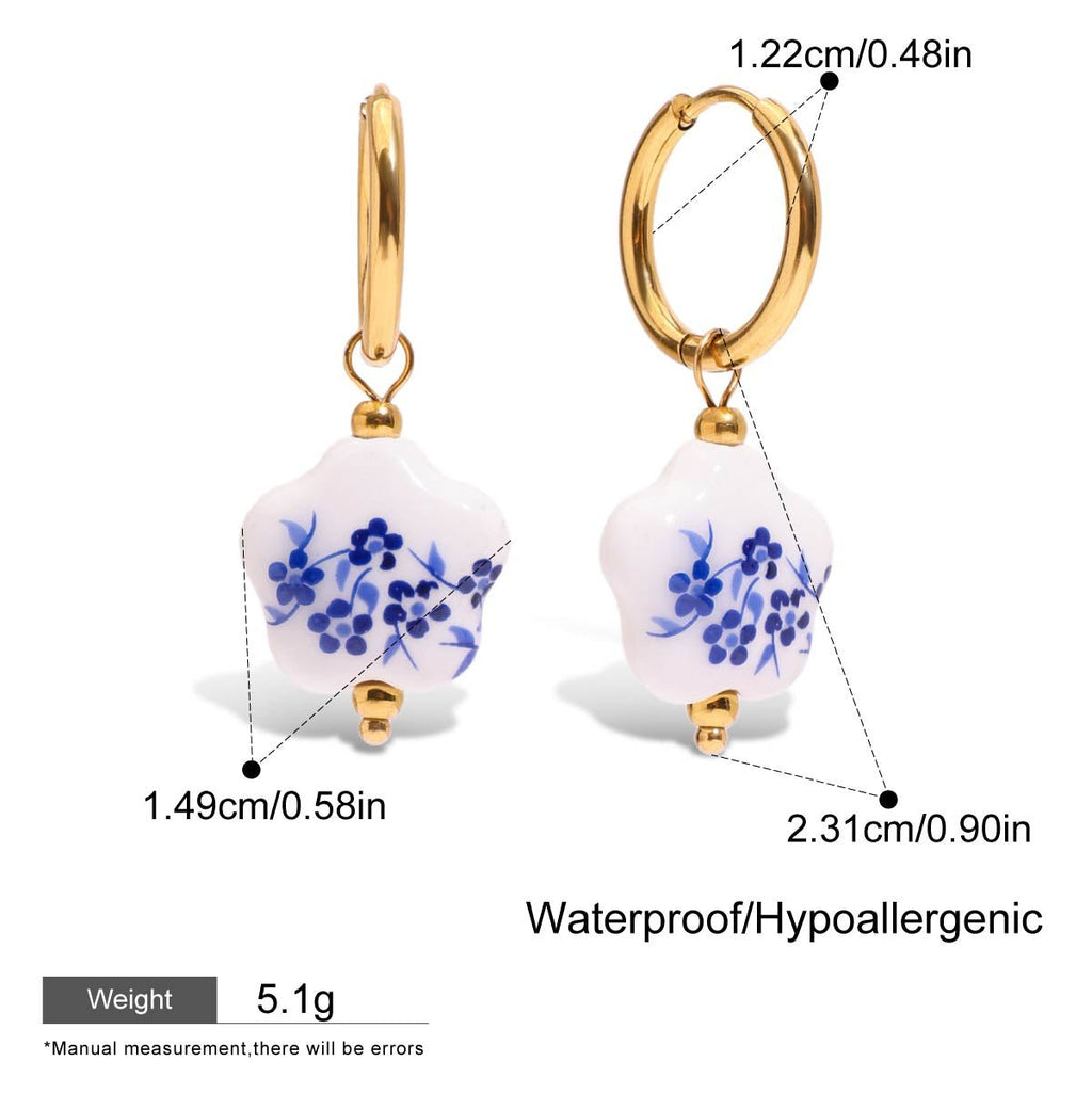 Gold hoop earrings with white and blue floral design, showing measurements and material details.