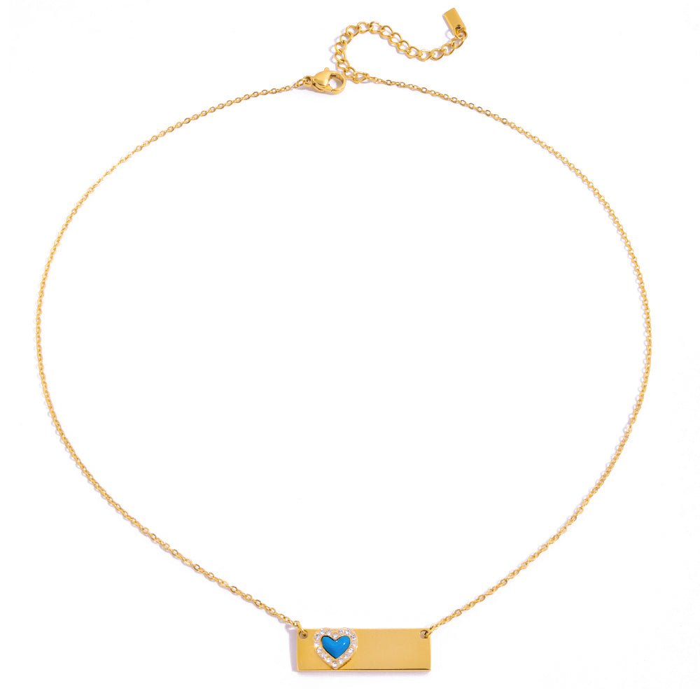 Gold necklace with a heart-shaped pendant on a white background
