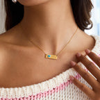 Gold necklace with a heart pendant worn by a person