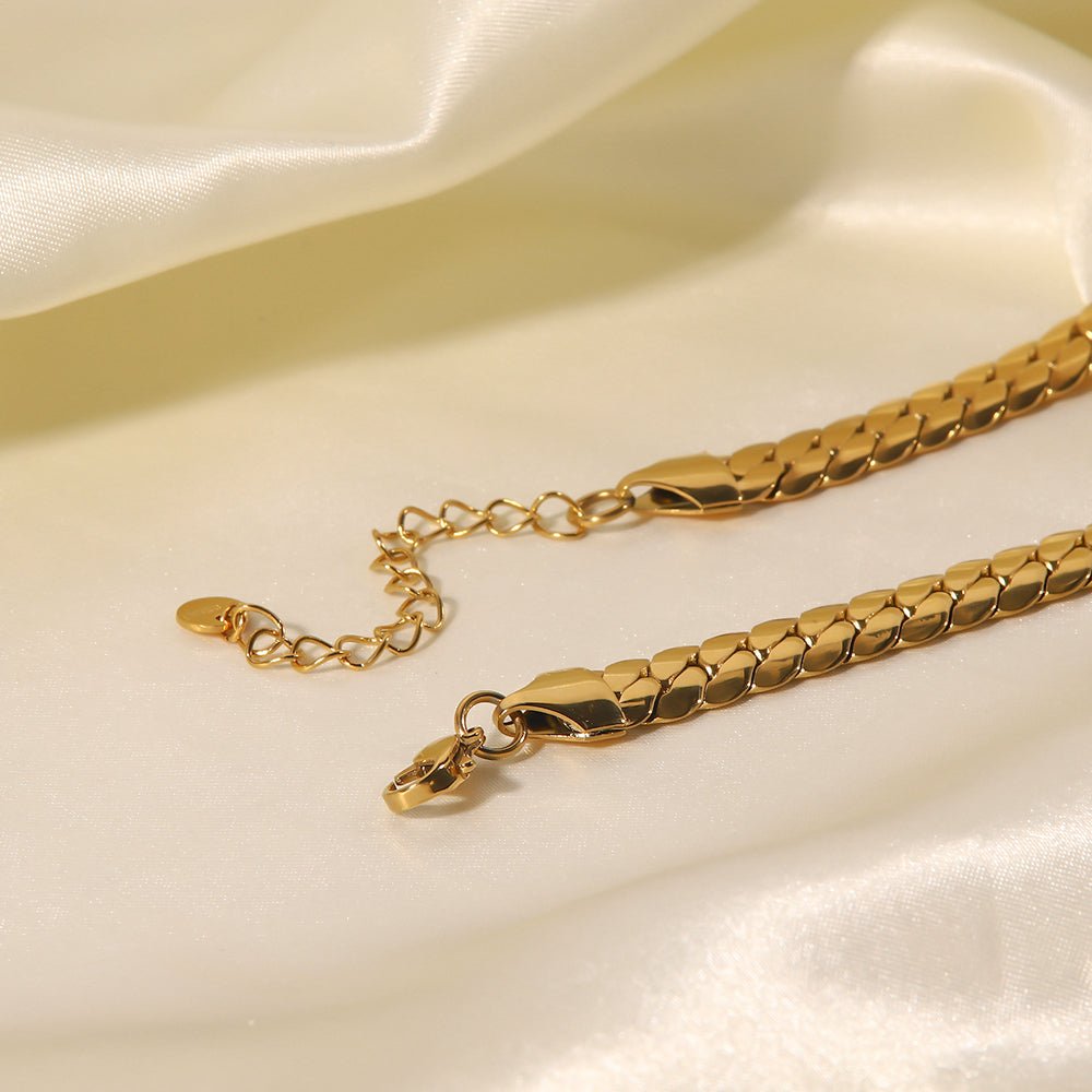 Gold chain bracelet on a soft beige fabric background