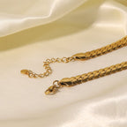 Gold chain bracelet on a soft beige fabric background