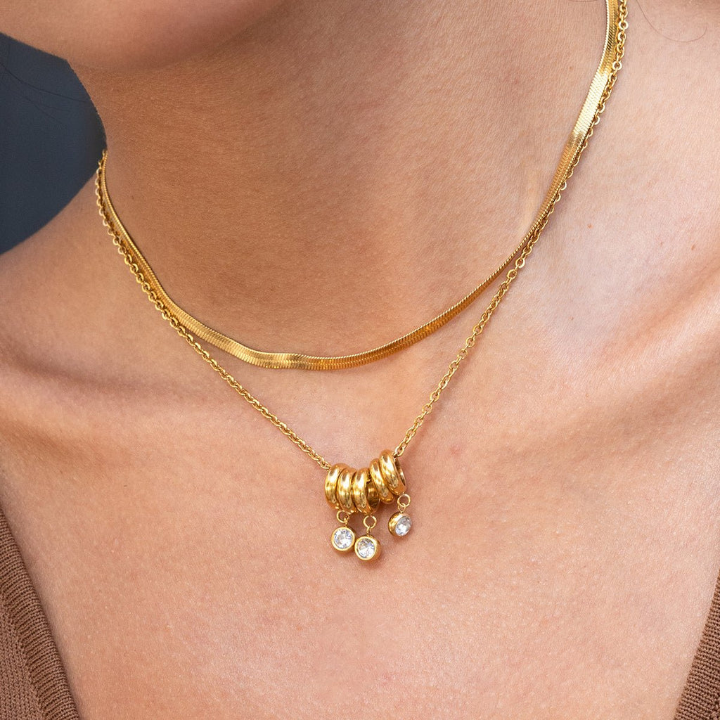 Gold necklace with beads and stones on a person's neck