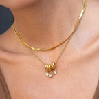 Gold necklace with beads and stones on a person's neck