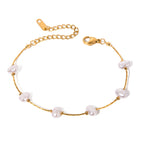 Gold bracelet with white pearls on a white background