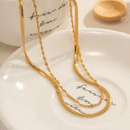 Gold necklace on a white dish with 'Fair Trade' text