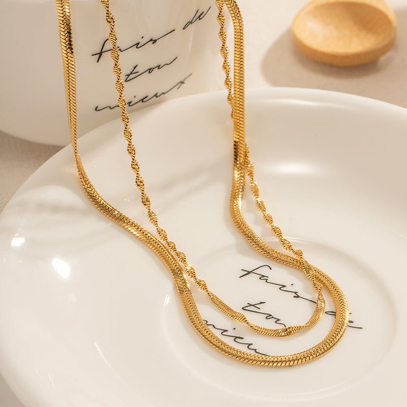 Gold necklace on a white dish with 'Fair Trade' text