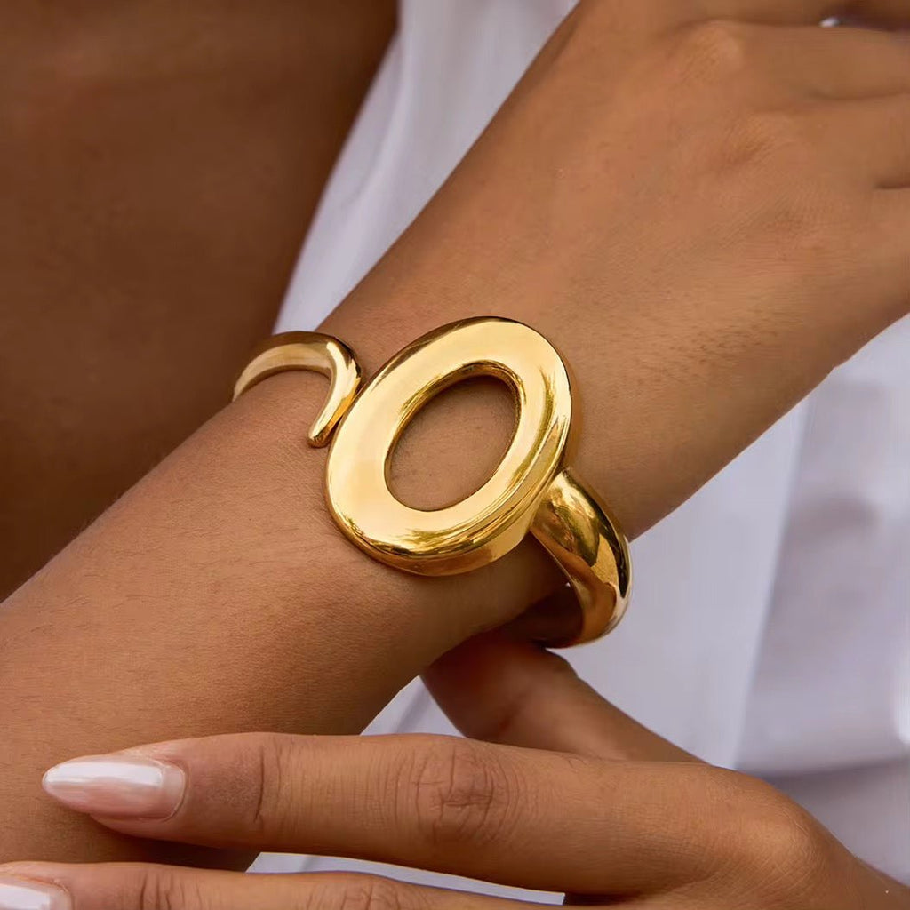 Gold bracelet on a wrist with a blurred background