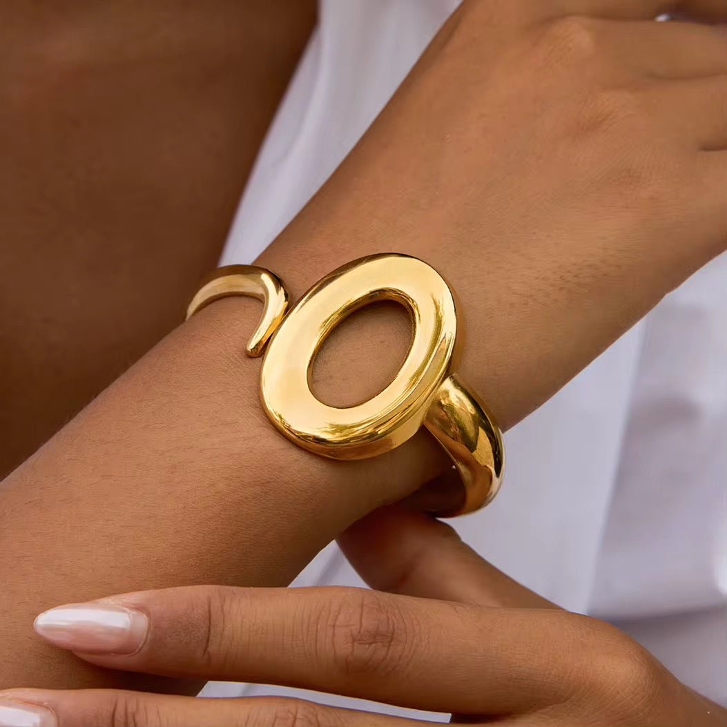 Gold bracelet on a wrist with a blurred background