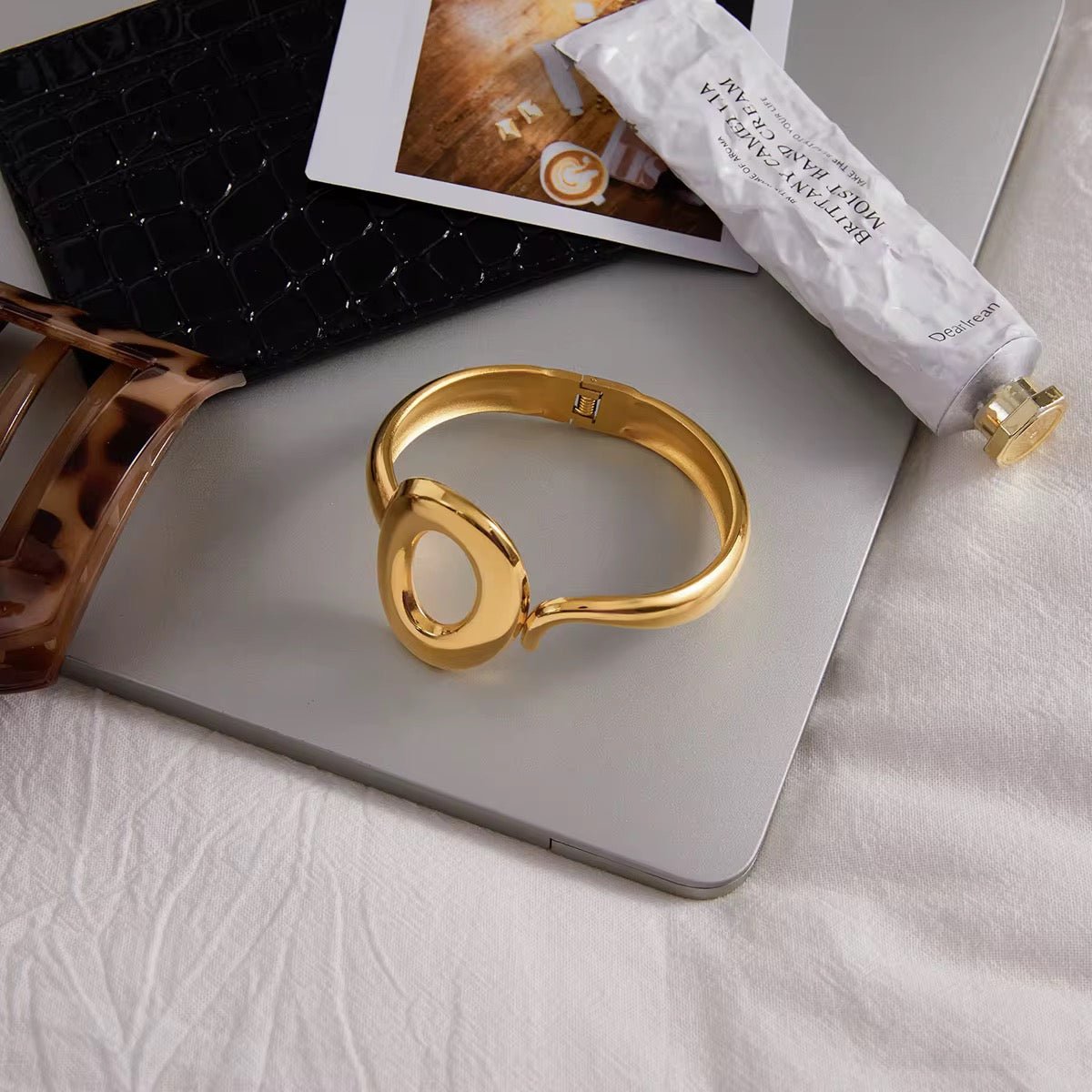 Gold bracelet on a laptop with a blurred background