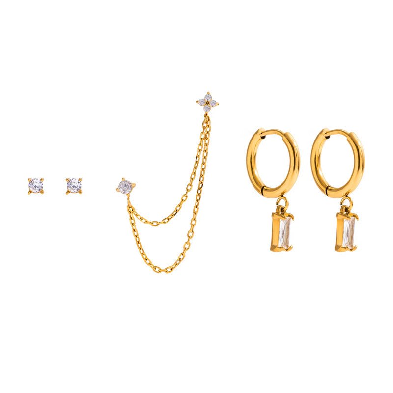 Gold jewelry set with earrings and a necklace on a white background