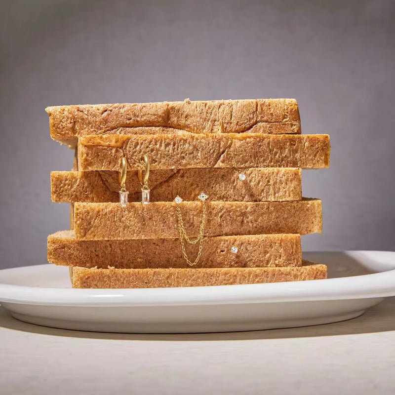Stack of toast with jewelry on a gray background