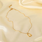 Gold necklace with a pendant on a beige fabric background