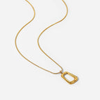 Gold necklace with a rectangular pendant on a white background