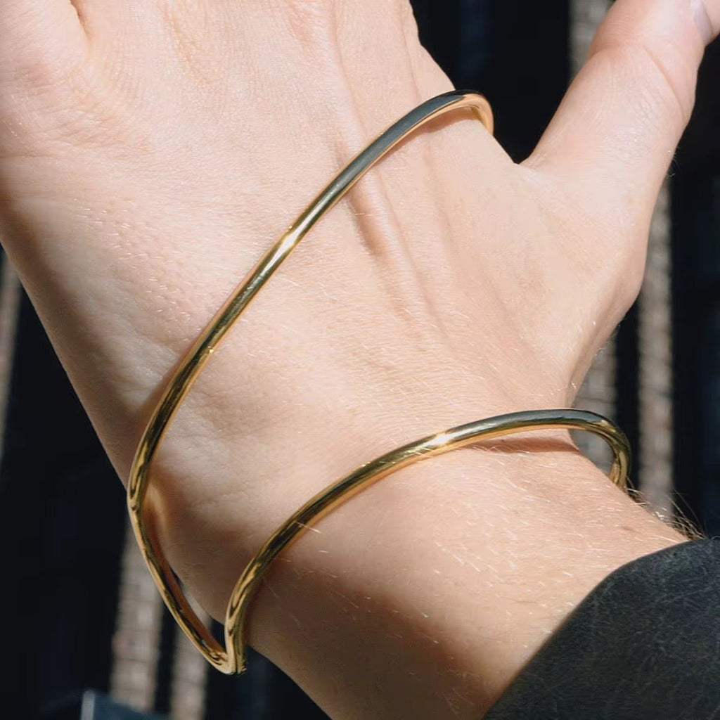Gold bangle on a person's wrist with a blurred background