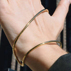 Gold bangle on a person's wrist with a blurred background
