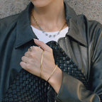 Person wearing a green leather jacket, white shirt, and gold jewelry.