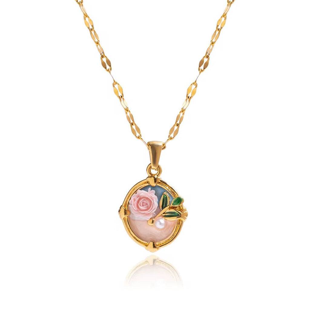 Gold necklace with a pendant featuring a rose and pearl on a white background