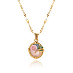 Gold necklace with a pendant featuring a rose and pearl on a white background