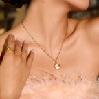 Close-up of a gold necklace with a pendant on a blurred background