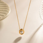 Gold necklace with a hexagonal pendant on a beige background